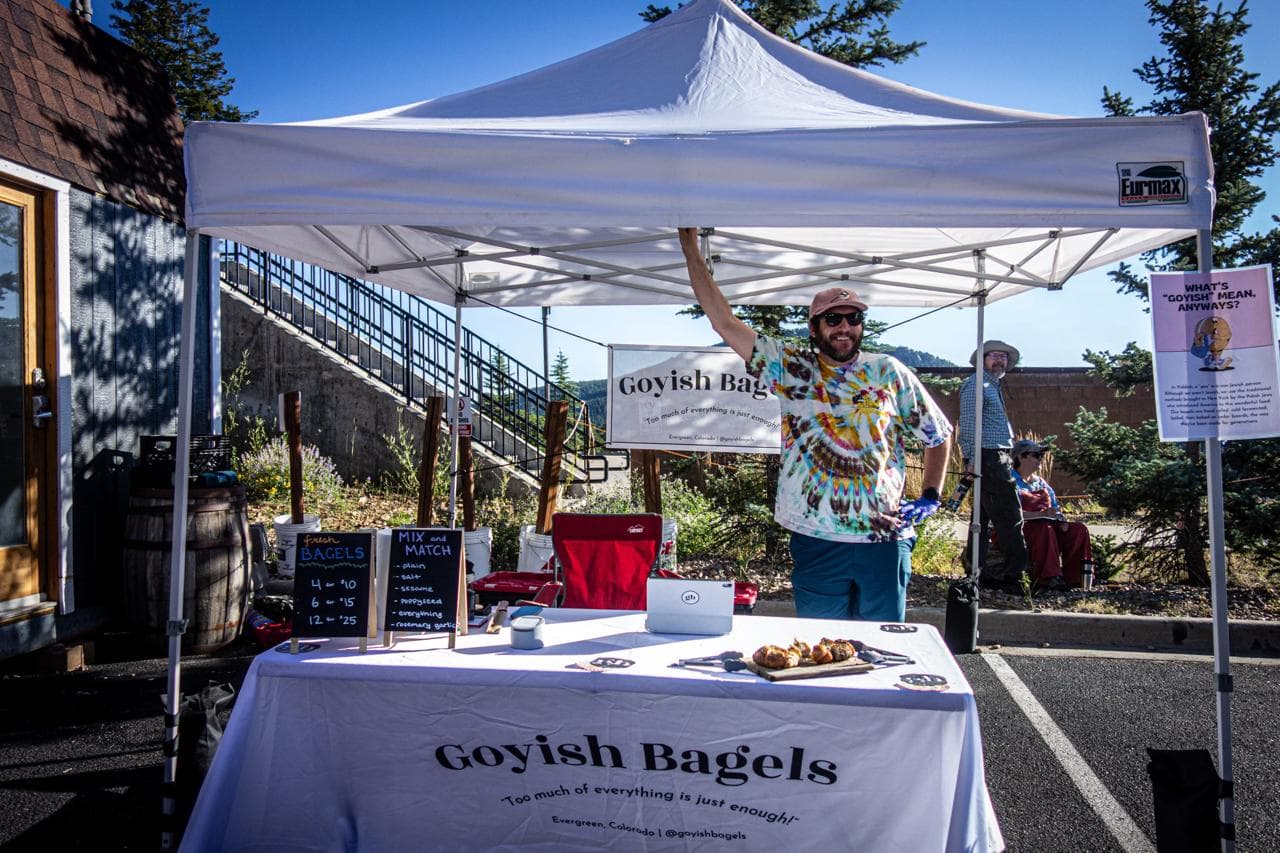 The Goyish Bagels tent, bagels on a board under a white canopy
